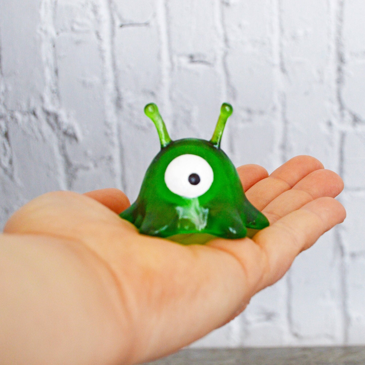 The brain slug is sitting in the palm of a woman&#39;s hand. It&#39;s pupil looks down and to the left.