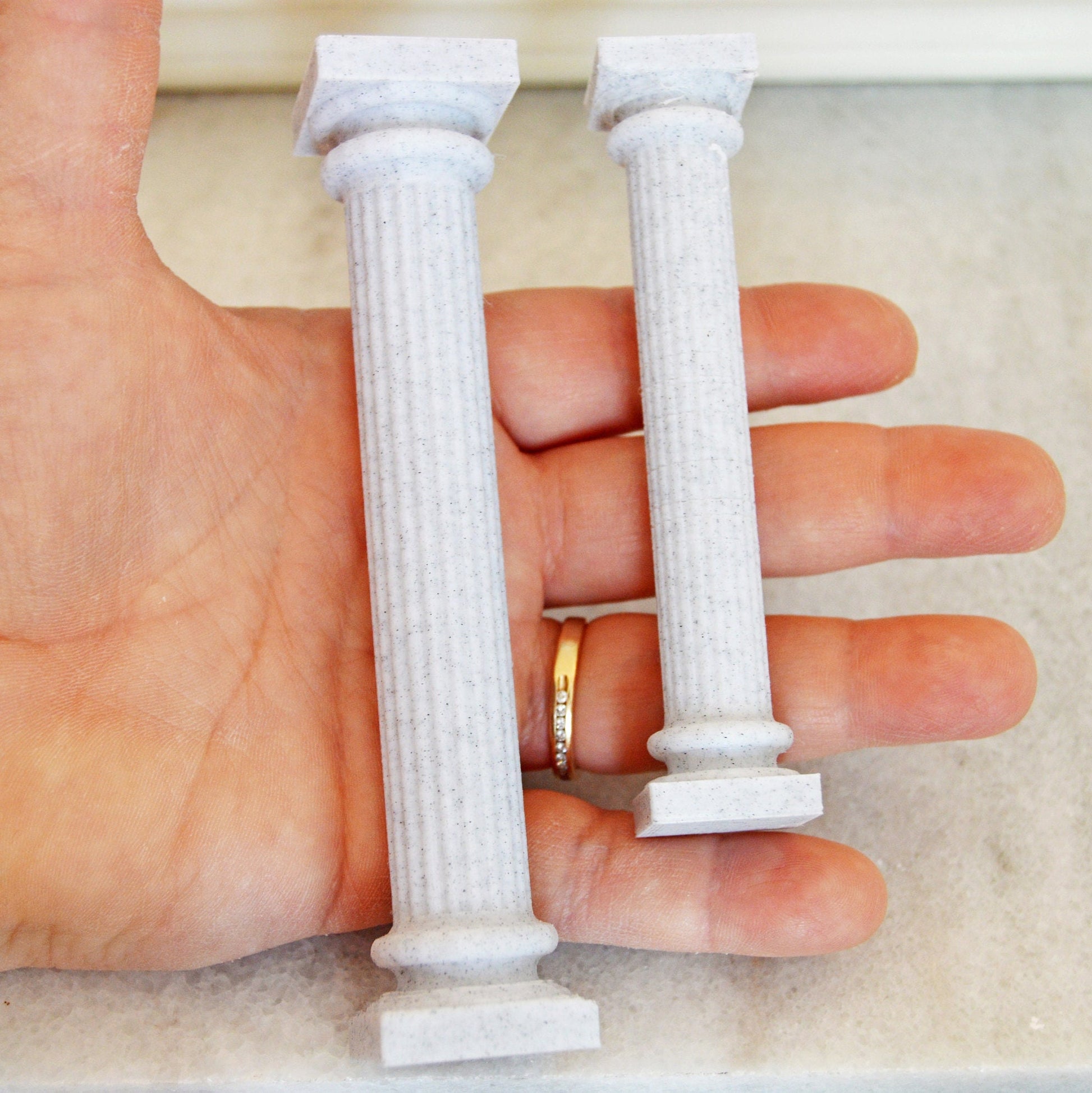 These are two larger pillars resting on a woman&#39;s hand.